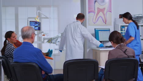 Doctor-talking-with-assistant-holding-teeth-x-ray