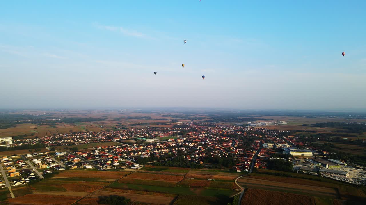 Stunning 4K aerial footage of a drone filming hot air balloons. Flying over farming fields and river. Filmed on a beautiful summer morning. Part of a hot air ballon festival in Prelog, Croatia.