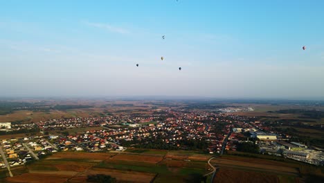 stunning 4k aerial footage of a drone filming hot air balloons. flying over farming fields and river. filmed on a beautiful summer morning. part of a hot air ballon festival in prelog, croatia.