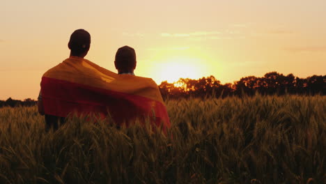 Two-Men-With-The-Flag-Of-Germany-Behind-Their-Shoulders-Are-In-A-Picturesque-Place-In-A-Field-Of-Whe