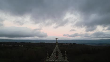 Lagarto-De-Piedra-Tallada-En-Arco-Sobre-La-Iglesia,-Retroceso-Aéreo-Para-Revelar-El-Paisaje-De-Ourense,-España