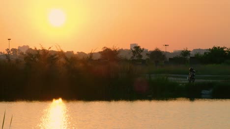 Motorcycle-parked-next-to-a-lake-during-sunset