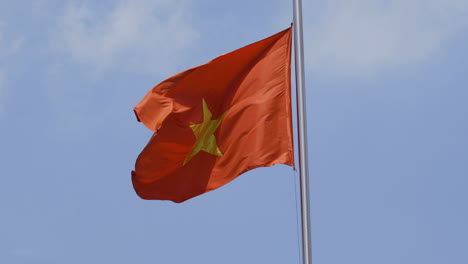 video 4k de la bandera nacional de vietnam bajo un sol brillante con cielo azul y fondo de nubes