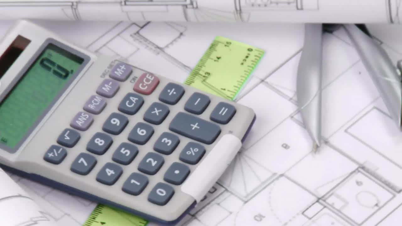 High view of plans and calculator turning
