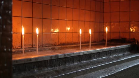 closeup of lit candles in a church