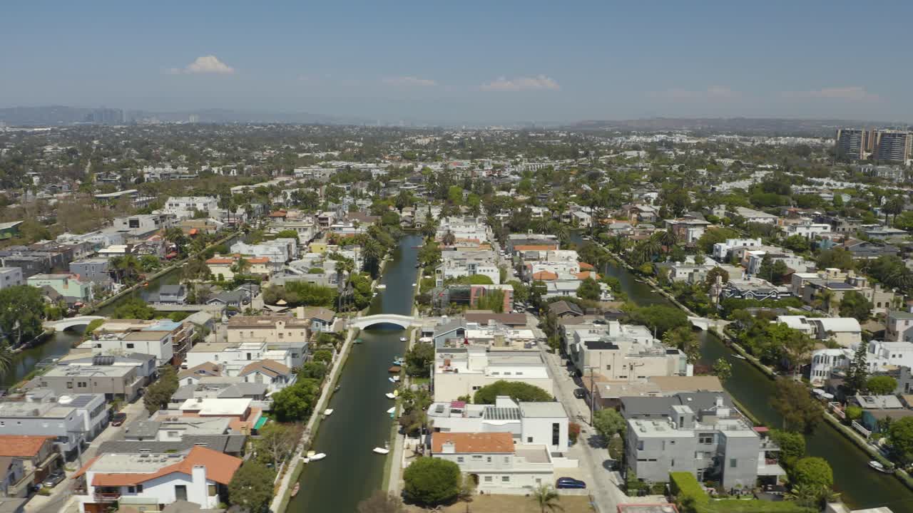 무인 항공기는 여름날 캘리포니아 로스 앤젤레스의 베니스 운하 위를 날아갑니다.