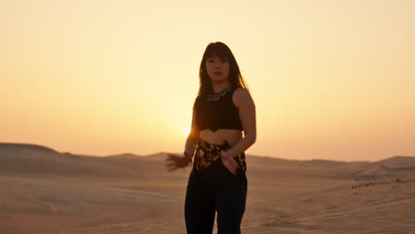 Mujer-Asiática-Sonriente-Bailando-En-El-Desierto-Del-Sahara-Al-Atardecer