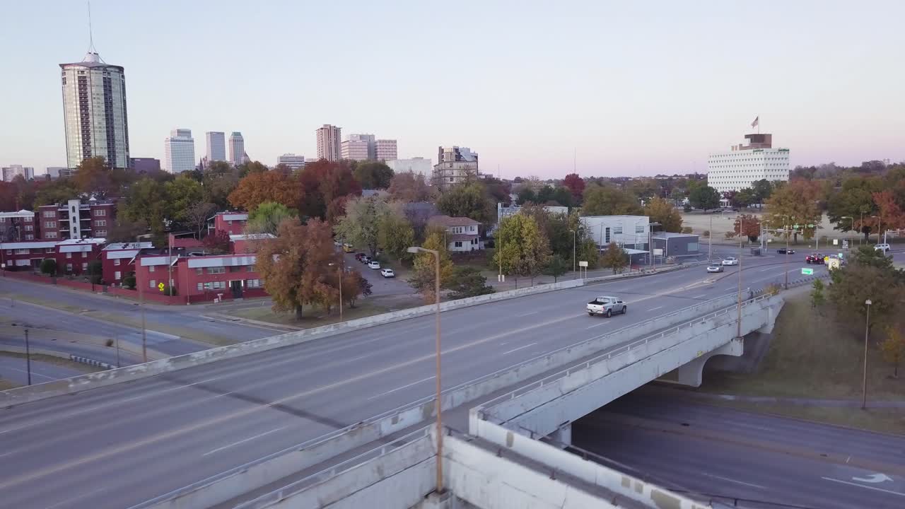 Aerial drone footage of downtown Tulsa crossing the Arkansas River at dusk.