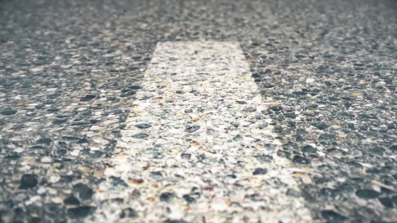 Close-up view of asphalt road surface with gravel