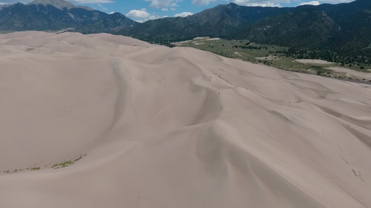 북아메리카에서 가장 높은 모래 언덕이 있는 콜로라도의 위대한 모래 언돌 위에서 촬영된 화려한 고도 비행 풍경 드론, 배경에는 산드레 드 크리스토 산맥이 있습니다.