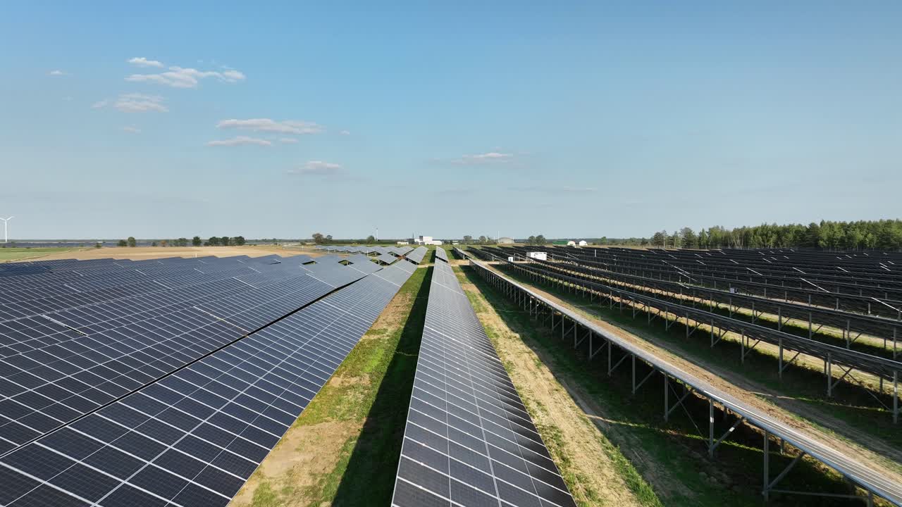 Drone flyver tæt på solcellepanel i et anlæg for vedvarende energi.