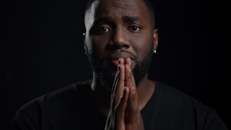 african american man begging indoors. male person making hand gestures in studio