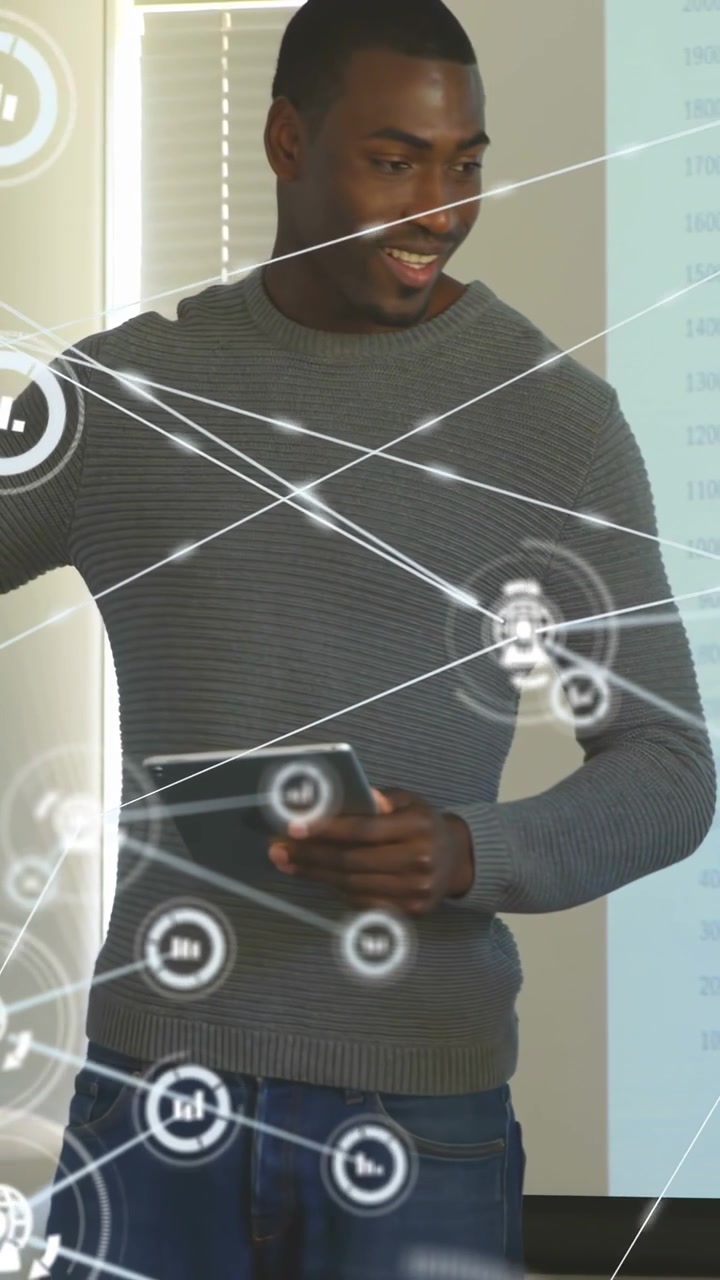 Vertical video: Seated man looking up host standing using tablet HUD explaining chart to host in IT