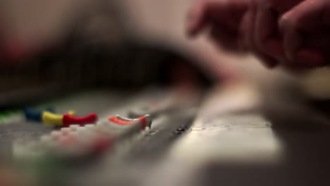hands adjusting audio mixing console