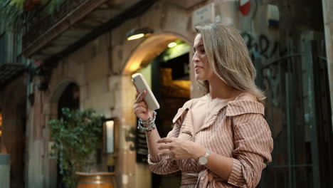 close-up view of smiling woman scrolling smartphone outdoor