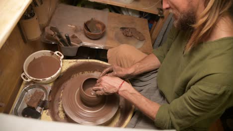 male hands making a clay bowl on a potter's wheel. handicraft and production of exclusive tea ware made of clay