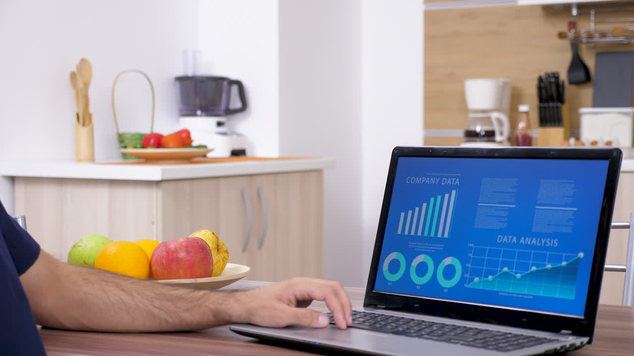 Working on data analysis on a laptop in the kitchen