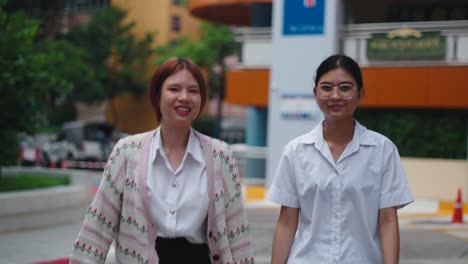 two young women walking together on campus