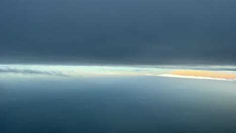 Aerial view from a jet cockpit while flying between layers of clouds in a cold winter afternoon