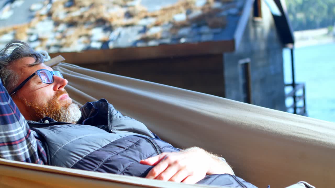 hombre relajándose en una hamaca en un día soleado 4k