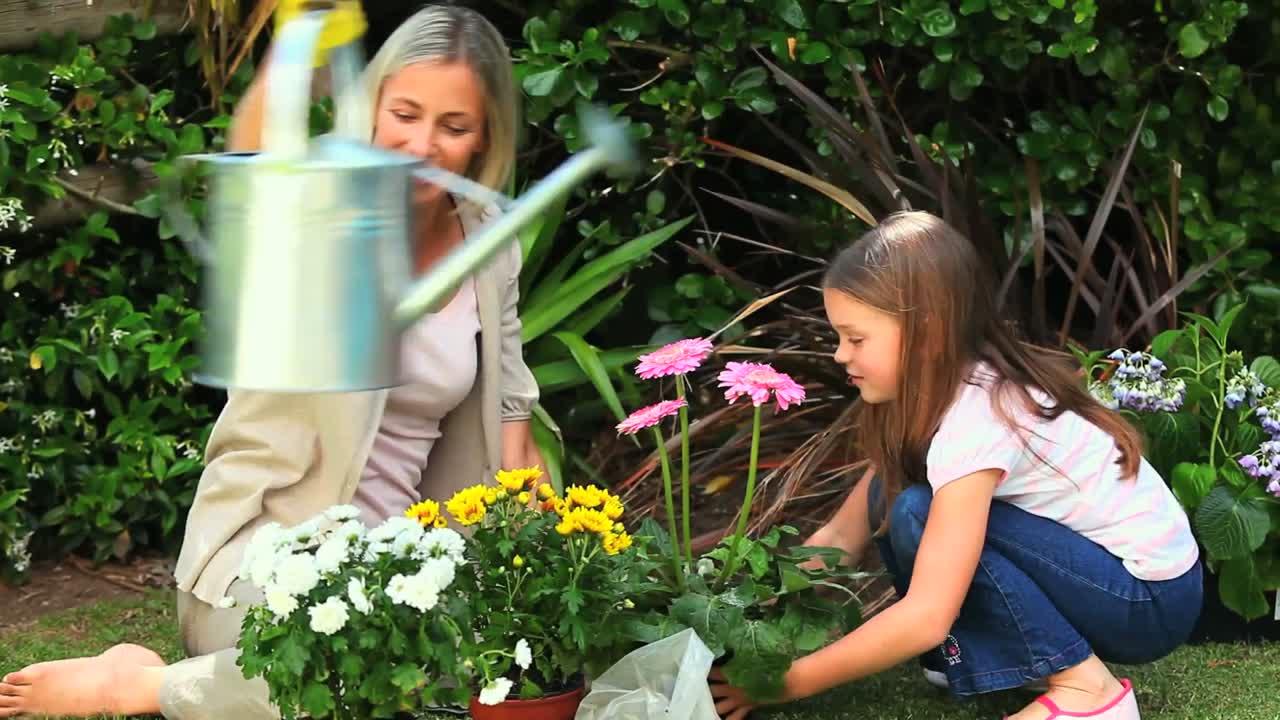 Mujer e hija haciendo jardinería