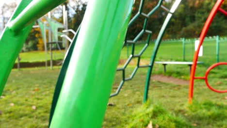disparo revelador lento a través de la zona de juegos para niños columpio barras de colores metálicos