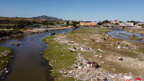 riverside of vietnam covered in piles of rubbish, aerial drone view on sunny day