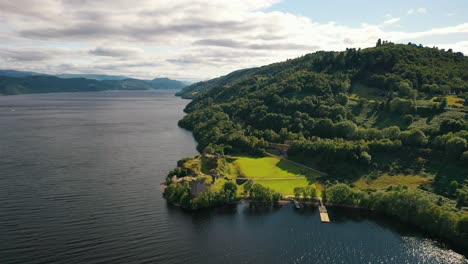 Antena-Sobre-El-Lago-Ness-Y-El-Castillo-De-Urquhart-En-Un-Día-Nublado-De-Verano,-Tierras-Altas-De-Escocia