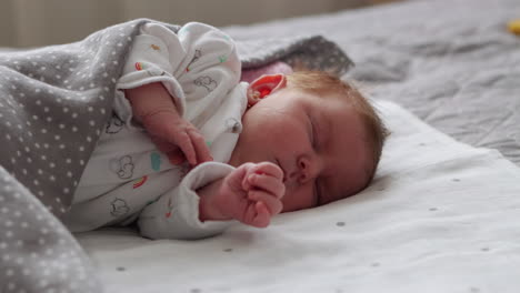 tiro medio de mano de una niña recién nacida durmiendo pacíficamente de lado