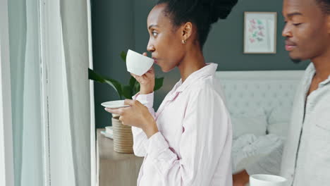 happy couple enjoying coffee by the window