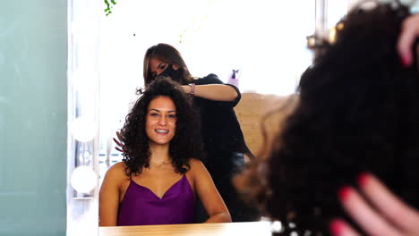 peluquero profesional haciendo peinado a una cliente de cabello largo