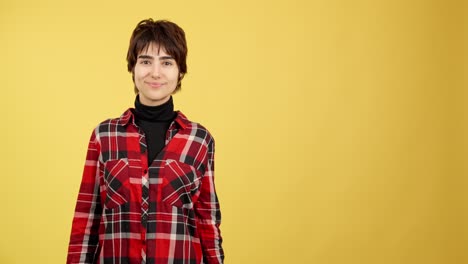 smiling woman with pointing and thumbs up gestures on yellow background