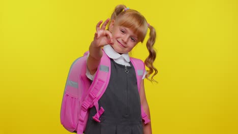 a young girl in a school uniform smiles and gives the okay sign