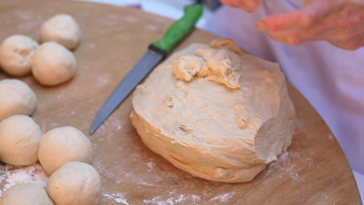 Hands preparing and dividing dough for baking