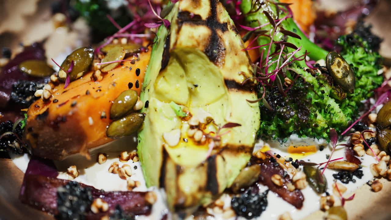 Close up of a salad with grilled avocado, sweet potato and broccoli on a plate at a restaurant