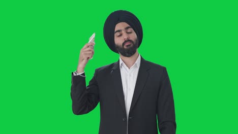 Egoistic-Sikh-Indian-businessman-using-money-as-fan-Green-screen