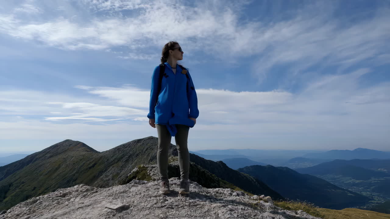 Woman standing on a mountain peak with a panoramic view