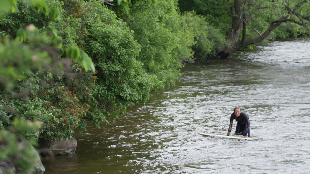 mujer atleta - surfing en una ola del río