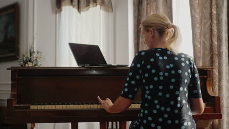 Woman-Learning-To-Play-The-Piano-Looking-At-Laptop-Screen