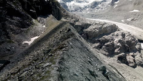 Fpv-Aéreo-Como-Un-Tiro-Que-Avanza-Trazando-La-Forma-De-La-Montaña-Con-Un-Glaciar-En-El-Fondo-En-Zinal,-Suiza