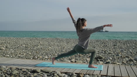 woman practicing yoga on a beach