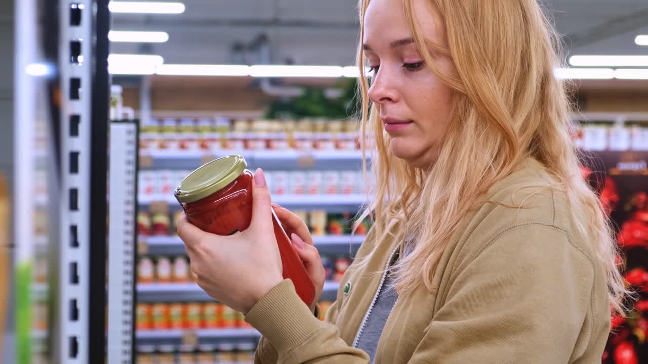A Young Woman Browsing Grocery Shelves in an Aisle Filled with Various Food Products, Engaging in a Thoughtful Selection Process