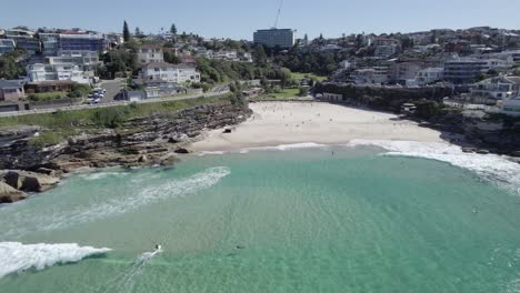 beachgoers and surfers at tamarama beach on a sunny day in nsw, australia