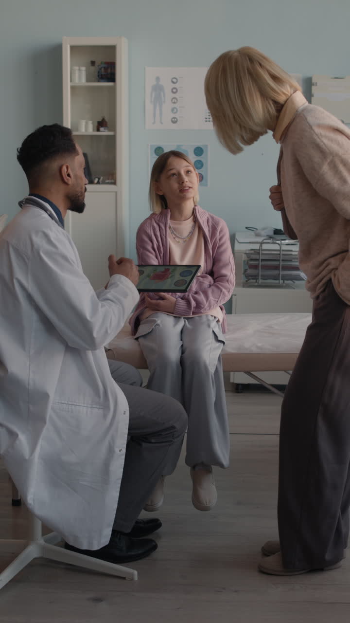 Doctor consulting with child and mother in examination room