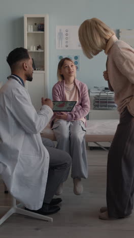 doctor consulting with child and mother in examination room
