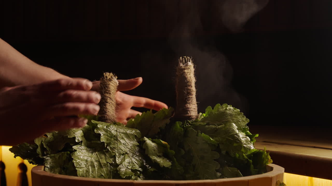 Preparing a traditional herbal sauna bath with oak leaves