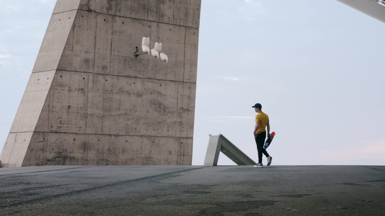 joven y atractivo hombre de moda patinando rápido bajo un panel solar en un día soleado por la mañana con un fondo urbano en cámara lenta