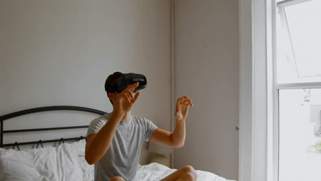 hombre usando auriculares de realidad virtual en la cama en el dormitorio 4k