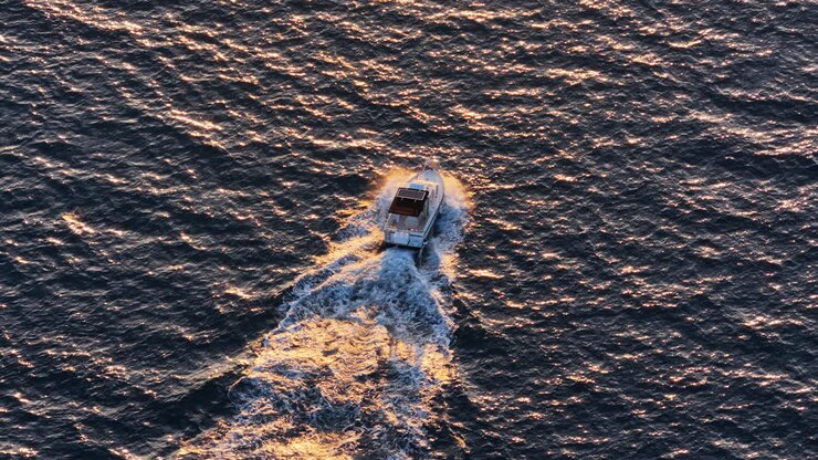 Aerial drone view of a boat riding at sunset
