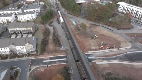 long freight train carrying oil tanks and commodities through city landscape, atlanta, georgia, usa
